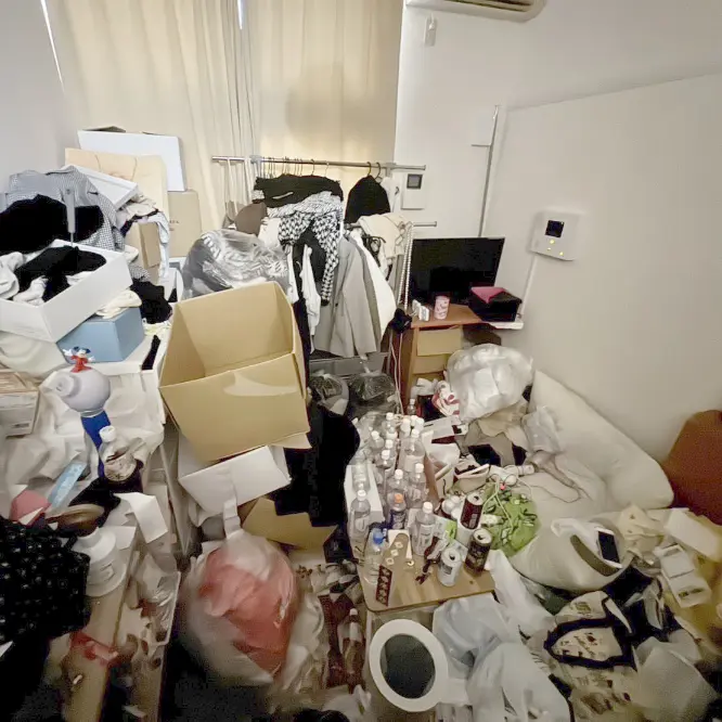 清掃前：大量のゴミで床が見えない散らかった部屋