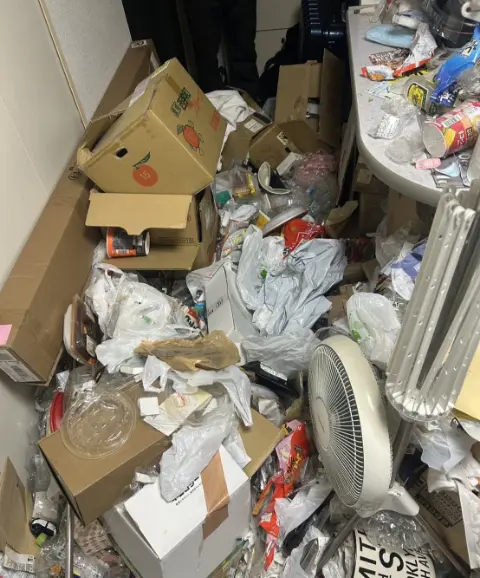 清掃前①：大量のゴミで床が見えない散らかった部屋