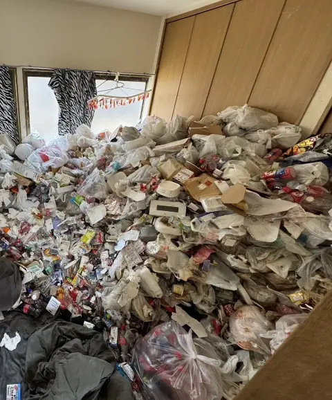 清掃前②：大量のゴミで床が見えない散らかった部屋